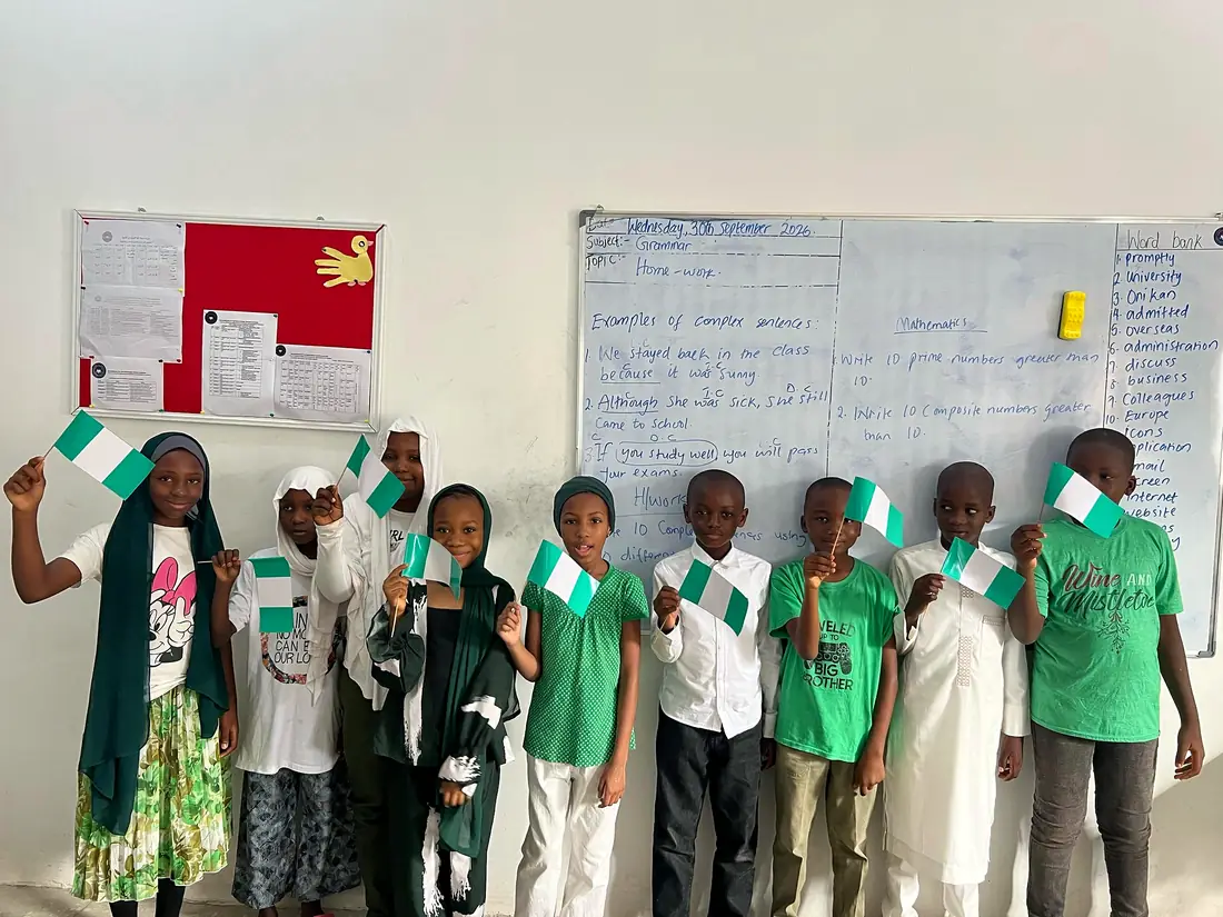 Pupils holding small Nigerian flags in class