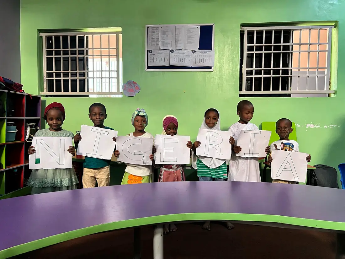 Young pupils proudly holding up their drawings