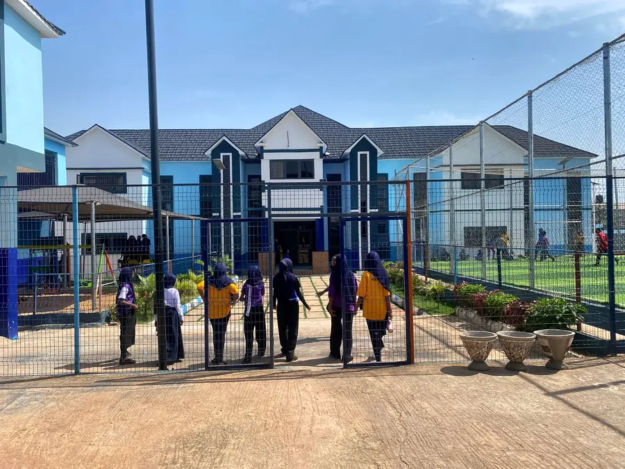 Pupils walking through the gate towards the main building