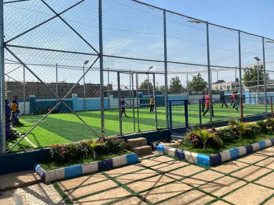 Pupils playing football on the netted turf pitch